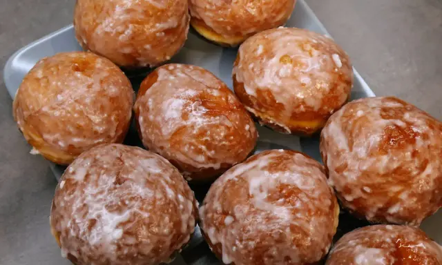 Puszyste pączki z piekarnika, oblane lukrem, kuszą swoim wyglądem. Idealne na tłusty czwartek lub jako słodka przekąska.