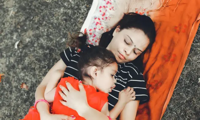 Mama i dziecko leżą przytuleni, uosabiając sztukę prostego życia. Ich spokój i bliskość to najpiękniejszy obraz.