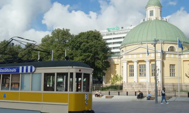 Żółty tramwaj na tle katedry i nowoczesnego budynku. Turku atrakcje to nie tylko zabytki, ale i miejska komunikacja.