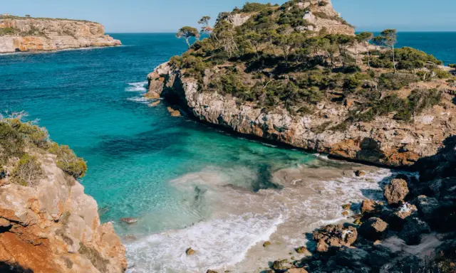 Malownicze wybrzeże z turkusową wodą i skalistymi klifami, idealne miejsce na wakacje na Palma de Mallorca.