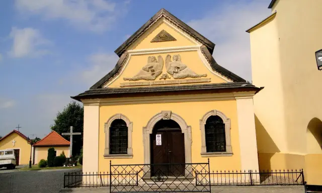 Żółta kaplica czaszek w Czermnej z aniołami i napisem "Kaplica Czaszek".
