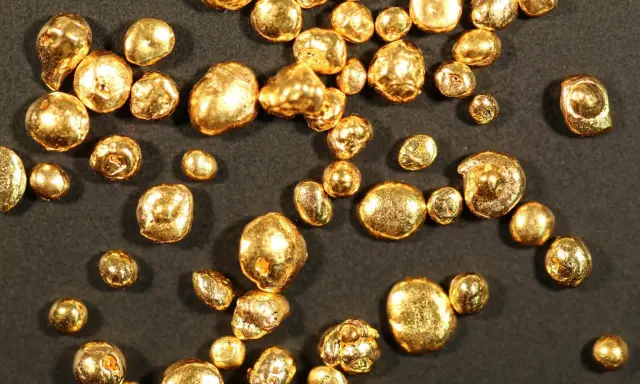 Grains d'or brut, certains ressemblant à des pépites, d'une pureté qui pourrait être du poinçon or 14 carats.