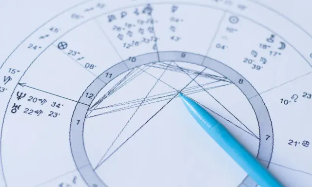 Zbliżenie na astrologia wedyjska kosmogram z niebieskim długopisem wskazującym na wykres.