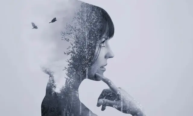 Silueta de mujer pensativa en **doble exposición**, con un bosque y dos cuervos volando.