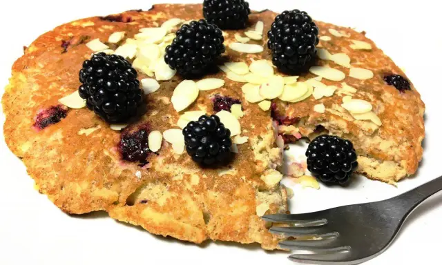 Omlet z jabłkiem i jeżynami, posypany płatkami migdałów. Pyszne śniadanie czeka na widelca.