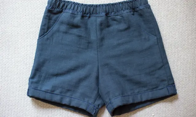 Mörkblå sy shorts med resår i midjan och fickor. Perfekta för lek och äventyr.