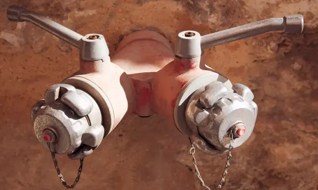 Dwa zawory hydrantu pożarowego, jeden z nich z widocznym czerwonym bolcem. Różne rodzaje hydrantów mogą mieć odmienne konstrukcje.