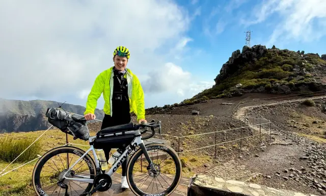 Glücklicher Radfahrer mit seinem Rennrad auf Madeira, bereit für eine Bergfahrt.