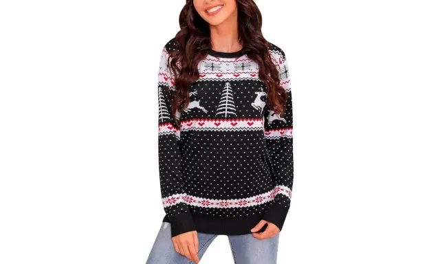 Mujer sonriente con jersey navideño casero negro con renos y árboles.