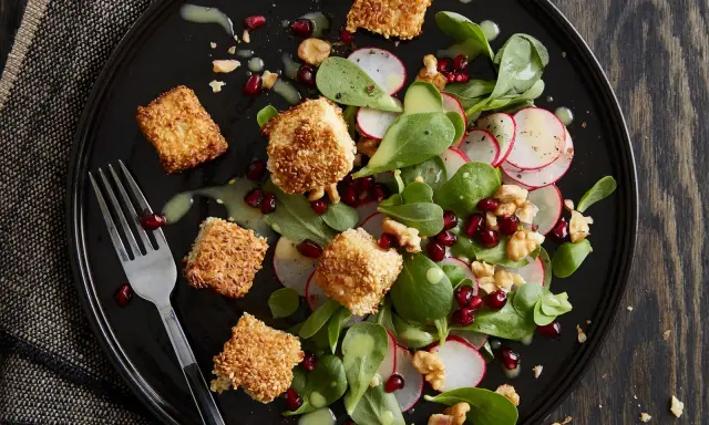 Feldsalat mit Radieschen, Walnüssen, Granatapfelkernen und knusprig panierten Käseecken.