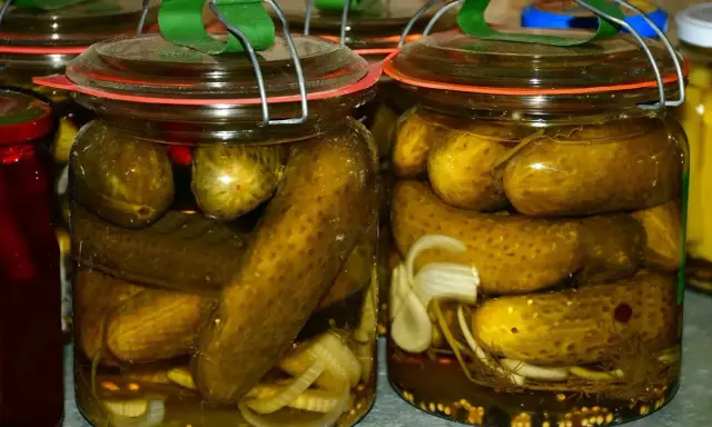 Słoiki pełne chrupiących ogórków po kaszubsku, z dodatkiem cebuli i przypraw, gotowe na zimę.