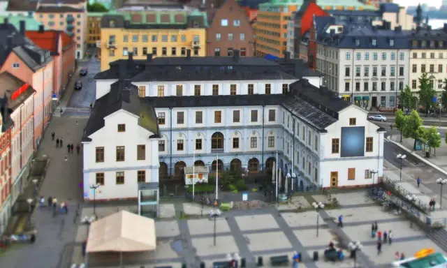 En vy över stadsmuseet i Stockholm med omgivande byggnader och en öppen plats med människor.