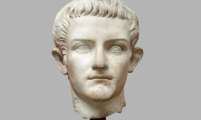 Marmorporträt eines jungen Mannes, der als Kaiser Roms identifiziert wird. Sein Haar ist kurz und wellig, die Augenhöhlen sind leer.