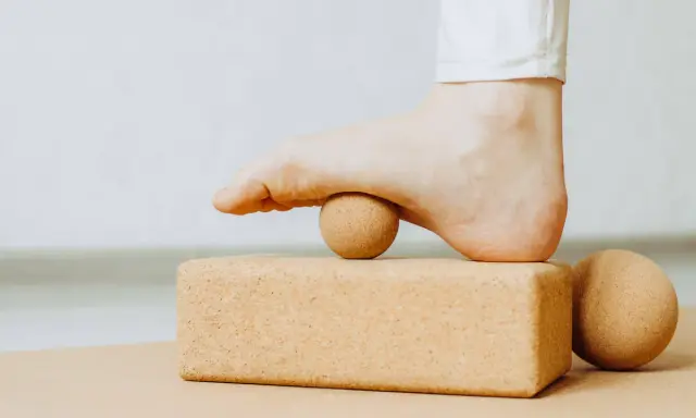 Fuß mit Ball auf Korkblock für Plantarfasziitis Dehnen.