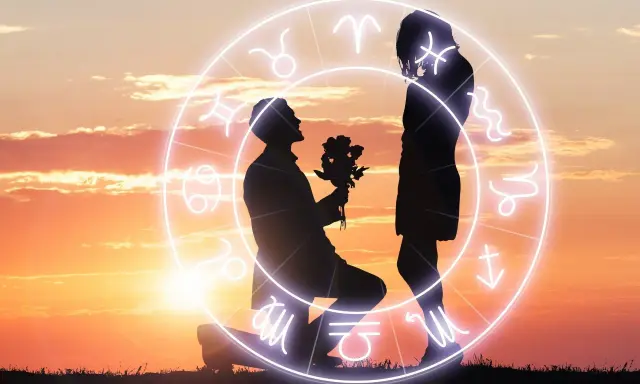Zodiakalny horoskop na dziś waga miłosny: mężczyzna klęczy z kwiatami przed kobietą, otoczeni kręgiem znaków zodiaku na tle zachodzącego słońca.