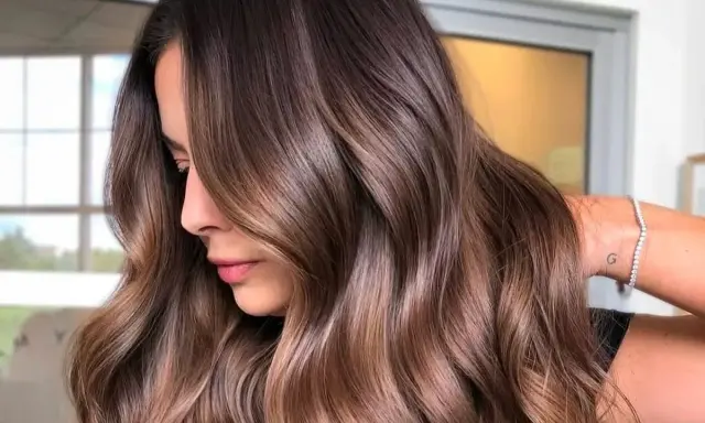 Capelli castani morbidi e luminosi, perfetti per un look estivo. Le onde leggere incorniciano il viso, creando un effetto naturale e chic.