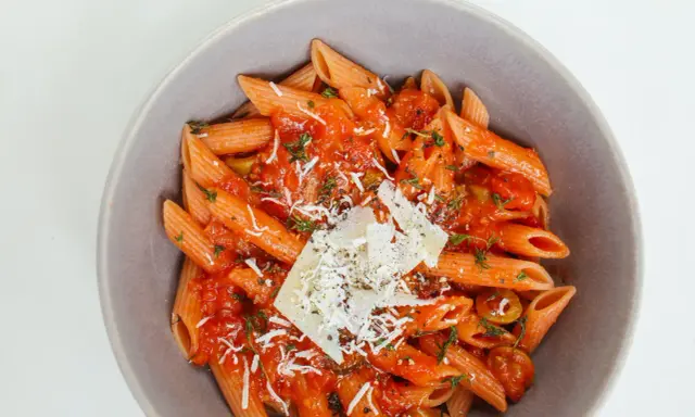Penne w sosie pomidorowym z ziołami i parmezanem. Idealny przepis na zdrowy makaron, który zachwyci smakiem.