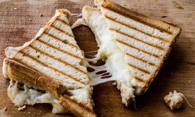 Pyszny, ciągnący się ser w tostach. Zastanawiasz się, ile kcal ma tost z serem? Ten wygląda na około 300-400 kcal.