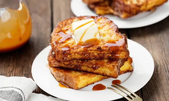 Pile de pain perdu salé doré, nappé de sirop et garni de beurre fondant. Un délice pour le petit-déjeuner.