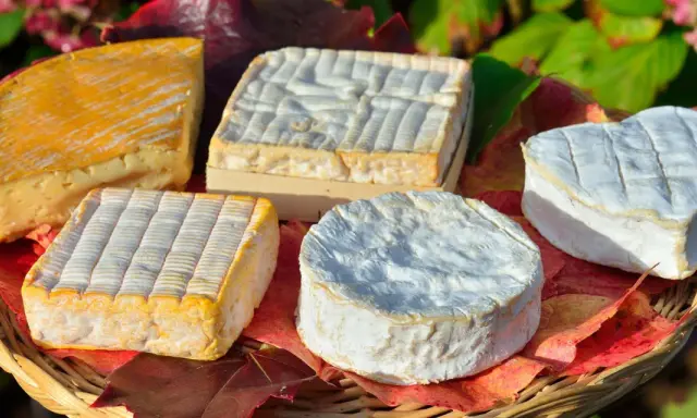Assortiment de fromages, dont un en forme de cœur, évoquant les spécialités culinaires de Rouen.