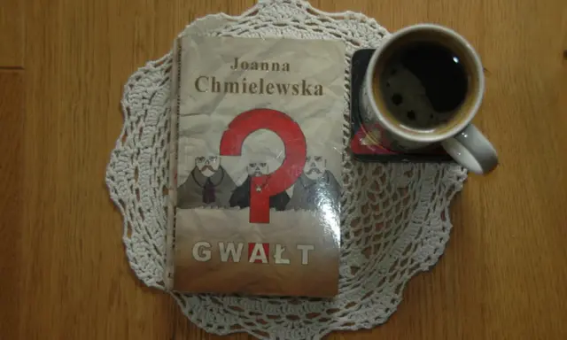 Kawa i książka Joanny Chmielewskiej "Gwałt" na koronkowym obrusie. Idealny zestaw do czytania jej kryminałów chronologicznie.