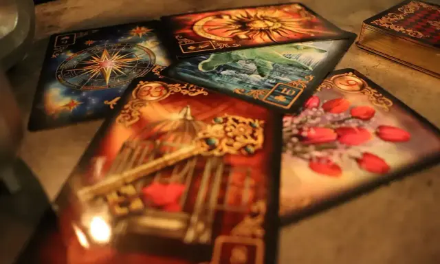 Magia kart odsłania obrazy: klucz do klatki, róże, słońce, kompas i wodę.