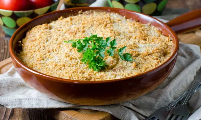 Un délicieux crumble de légumes, doré et croustillant, garni de persil frais. Parfait pour un repas réconfortant.