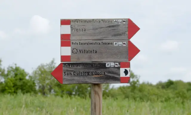 Cartello segnaletico per il trekking in Val d'Orcia: Pienza, Vitaleta e San Quirico d'Orcia.