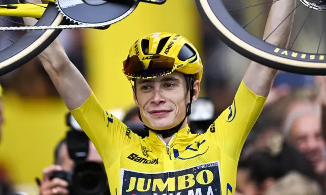 Jonas Vingegaard im Gelben Trikot, mit seinem Rad über dem Kopf. Sein Gehalt ist wohl hoch, bei diesem Erfolg!