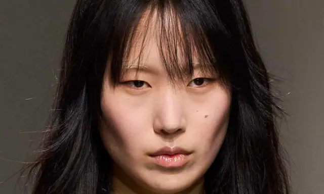 Rostro de modelo con cabello negro y flequillo desordenado, un corte **hush cut** que enmarca su rostro.