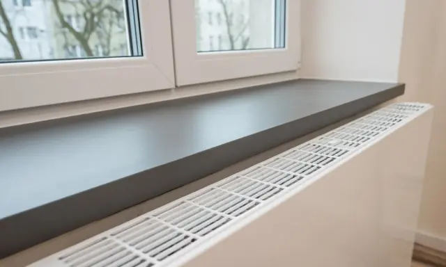 Ciemnoszary parapet idealnie komponuje się z białymi oknami, tworząc nowoczesną aranżację wnętrza.