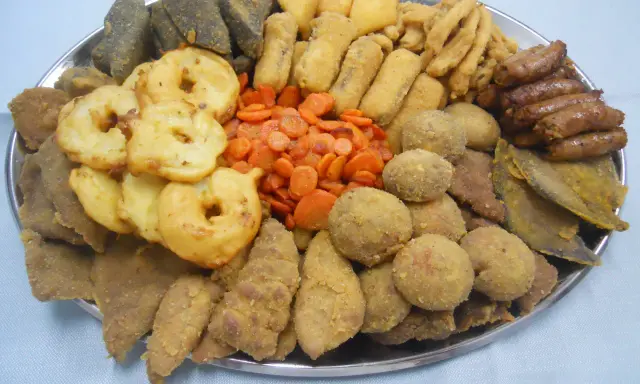 Vassoio con vari piatti tipici torinesi: frittelle, verdure, polpette e salumi.