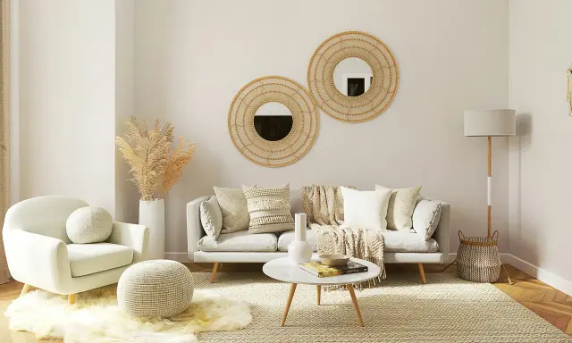 Un salon boheme nature avec un fauteuil douillet, un canapé confortable, des coussins texturés, des miroirs en rotin et des herbes séchées.
