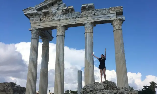 Radosna turystka pozuje na tle antycznych ruin w Side, Turcja.