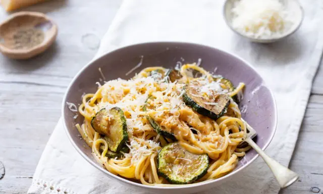Pyszny makaron z cukinią i pieczarkami, posypany parmezanem. Idealny lekki obiad.