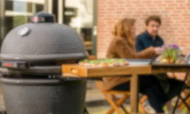 Un couple profite d'un repas en plein air avec une pizza fraîchement préparée, la cuisson kamado promettant une saveur incomparable.