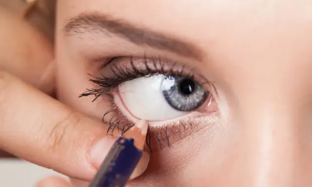 Applicazione di matita sotto l'occhio per uno sguardo intenso. Un tocco di colore che valorizza gli occhi.