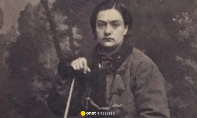 Portret Anny Pustowójtówny w stroju z epoki, oparta o laskę.