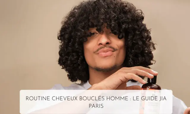 Un homme aux cheveux bouclés tient un flacon de shampoing, parfait pour l'hydratation cheveux bouclés.