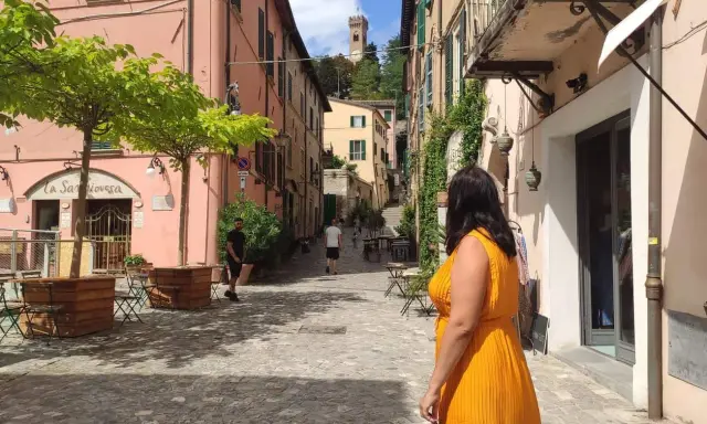 Un vicolo pittoresco con un campanile in lontananza, perfetto per scoprire cosa vedere vicino Rimini.