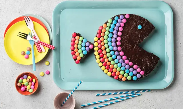 Un délicieux gâteau chocolat en forme de poisson, décoré de bonbons colorés. Parfait pour une fête !