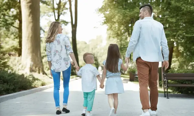 Familia paseando por un parque, ideal para saber qué hacer en León con niños y disfrutar del aire libre.