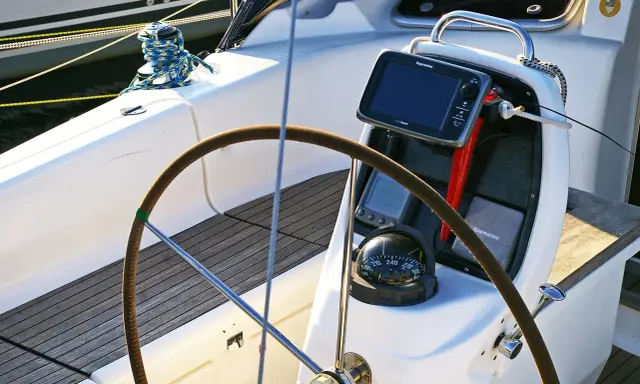 Timone, bussola e GPS su una barca a vela. Il timoniere, chi guida la barca, si affida a questi strumenti per la navigazione.
