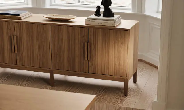 Ett vackert sidobord i trä med böcker och skulpturer på. Perfekt för att styla ditt hem.