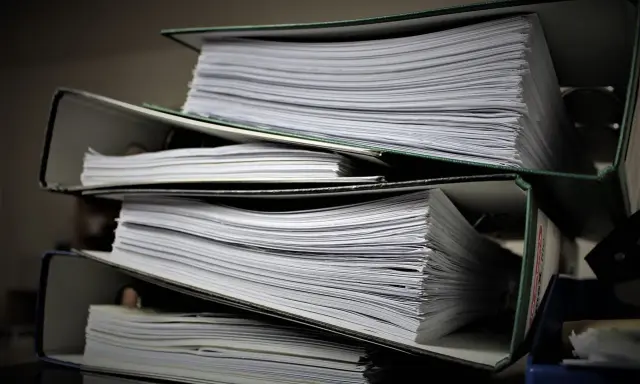 Stosy dokumentów w segregatorach. Może to być materiał do analizy, ale też dowód na to, że popełniono błąd i teraz potrzebny jest czynny żal.