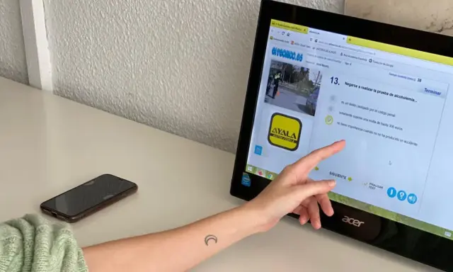 Persona estudiando para el examen teórico de conducir, resolviendo preguntas sobre multas y delitos. Averigua cuántos fallos se pueden tener en el examen teórico de conducir.