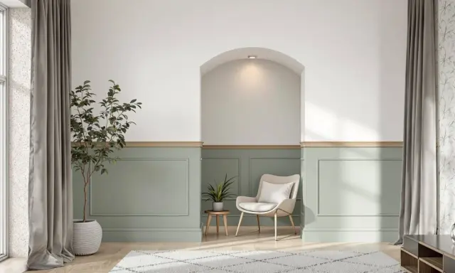 Un salon moderne avec un soubassement de mur peint en vert pâle, orné de moulures. Une niche cintrée au-dessus apporte une touche architecturale.