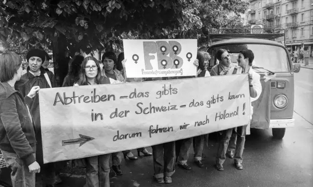 Frauen demonstrieren für das Recht auf Abtreibung. Die Botschaft "Abtreiben – das gibts in der Schweiz – das gibts kaum, darum fahren wir nach Holland!" zeigt eine frühe Welle des Feminismus.