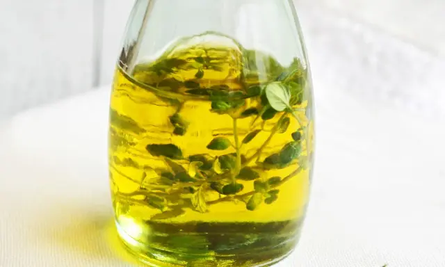 Złocisty olejek tymiankowy w szklanej butelce, z gałązkami tymianku w środku. Idealny do aromatyzowania potraw. Jak stosować?