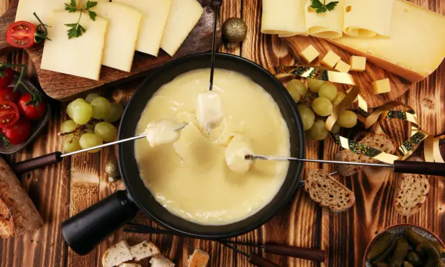 Fondue au fromage, une des spécialités d'Auvergne, accompagnée de pain, raisins et tomates cerises.